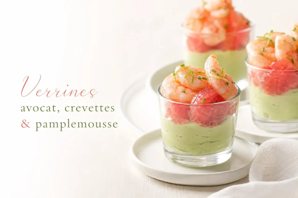 Entrées froides : verrines avocat, crevettes et pamplemousse dressées sur une table élégante